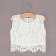 White lace top on a wooden hanger against a gray background