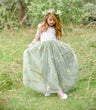 pretty child holding her dress in field