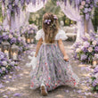 Young girl in a floral dress walking through a beautifully decorated outdoor setting with flowers and lanterns.