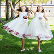 Girls playing in white flower girl dresses