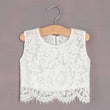 White lace top on a wooden hanger against a grey background