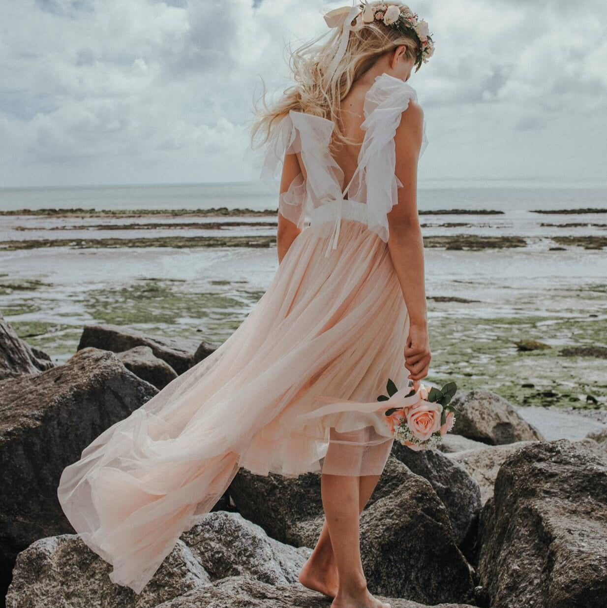 YOUNG GIRL STANDING ON A BEACH
