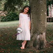 young girl holding flowers by tree