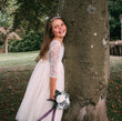 young girl holding flowers by tree