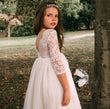 young girl holding flowers by tree
