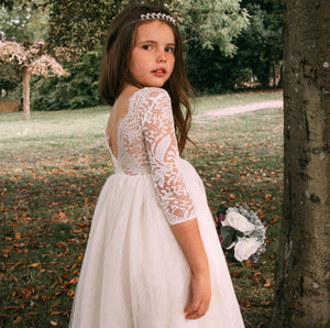 young girl holding flowers by tree