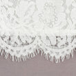 Close-up of white lace fabric on a grey background