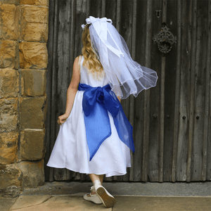 girl in a white flower girl dress showing the detail on the back