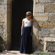 Girl skirt standing against a stone wall.