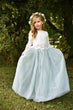 young girl standing holding her dress