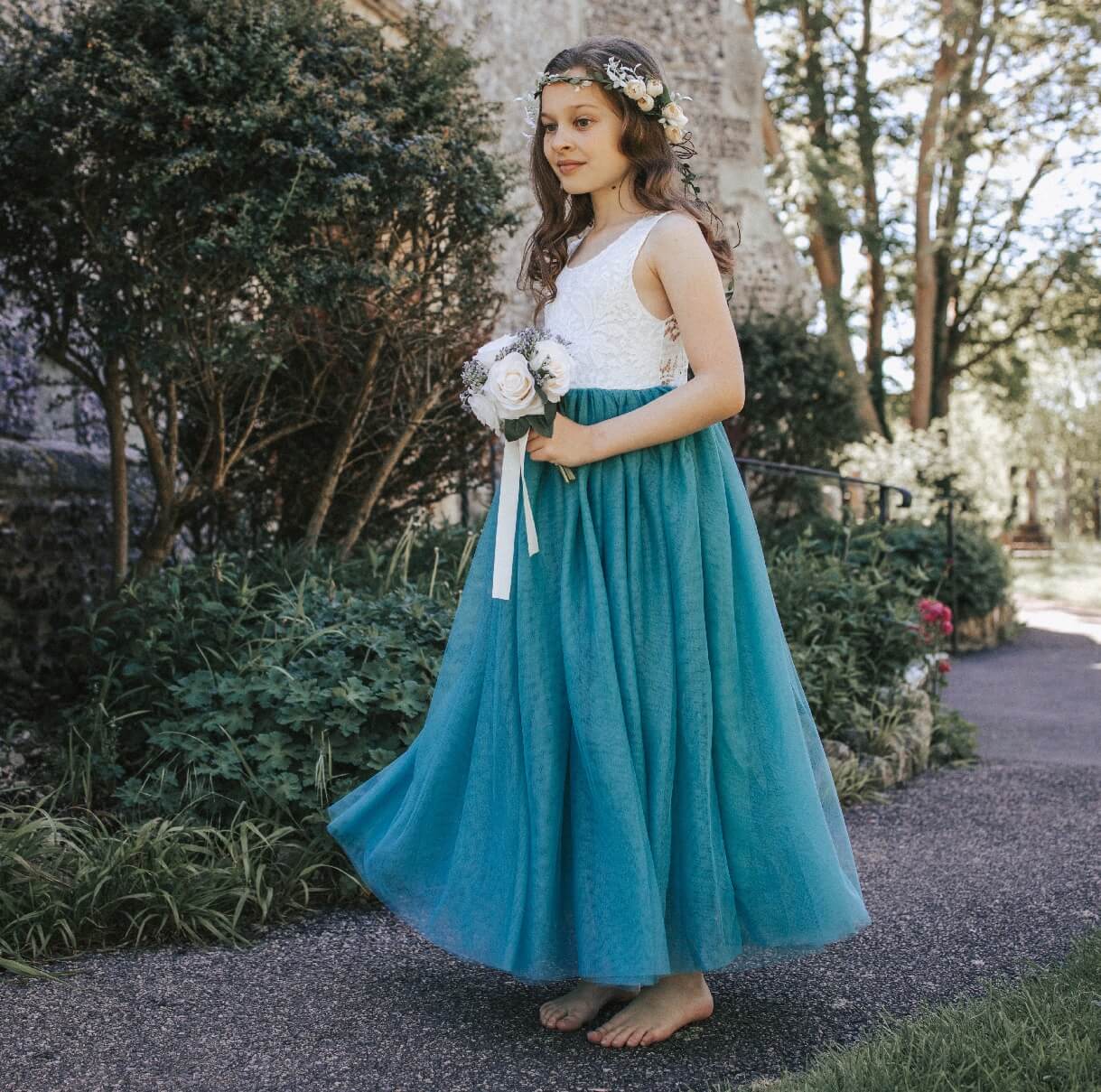 young girl wearing a teal flower girl dress