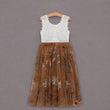 A sleeveless girl's dress hanging on a wooden hanger against a solid gray background. The dress has a white lace bodice and a brown tulle skirt with a floral print.