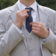 Boy straightening a navy coloured  tie