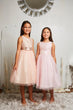 2 dresses in blush and baby pink worn together