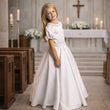 Young girl in a white dress standing in a church setting