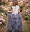 Young girl in a floral dress standing in a cherry blossom garden