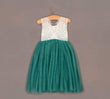 Teal and white dress on a hanger against a gray background