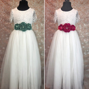 Green and red floral sashes on white dresses