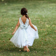 Girl in a park in silver uk flower girl dress with sequin bow