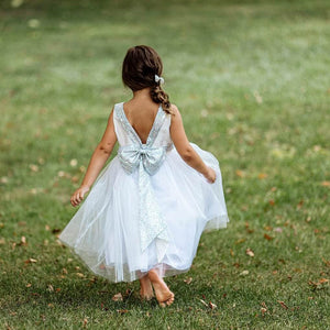Girl in a park in silver uk flower girl dress with sequin bow