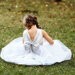 Girl sitting on grass in silver uk flower girl dress