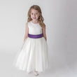 Girl in white party dress with purple sash