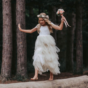 Girl holding bouquet and walking on log