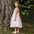 girl in a garden wearing Belle of The Ball lace and sequin dress