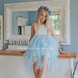 Girl in a white an blue party dress sitting in front of a mirror