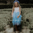 girl in a garden in a blue and white bohemian party dress