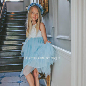 Blonde girl in a bohemian party dress at the bottom of some stairs