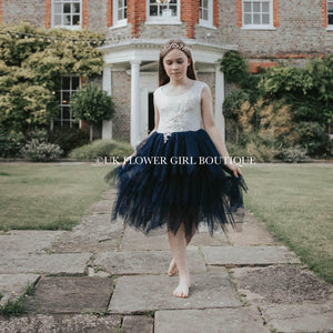 Girl wearing navy blue dress outside mansion